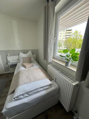 a small bed in a room with a window at Hostel by BookieBooking in Wiesbaden
