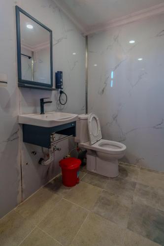 a bathroom with a sink and a toilet and a mirror at Mayas Stay in Busia
