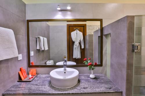 a bathroom with a sink and a mirror at Avari Xpress Faisalabad in Faisalabad