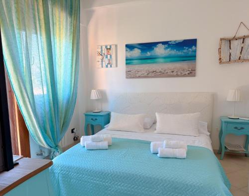 a bedroom with a blue and white bed with pillows at LE TERRAZZE Apartment - spacious and charming apartment near the sea and beach, close to the train station with hourly trains to Rome - Lido delle Sirene, Anzio in Anzio