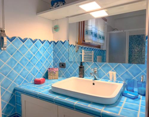 a bathroom with a sink and a blue tiled wall at LE TERRAZZE Apartment - spacious and charming apartment near the sea and beach, close to the train station with hourly trains to Rome - Lido delle Sirene, Anzio in Anzio