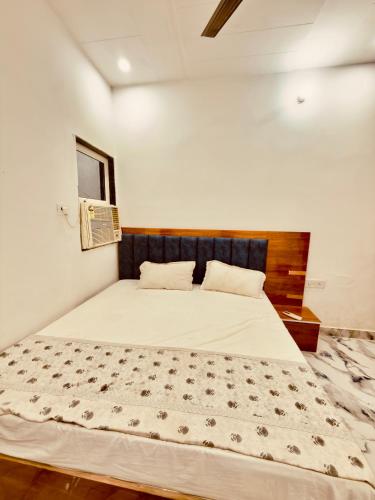 a bedroom with a large bed with a wooden headboard at Shri charno amrit vatika in Vrindāvan