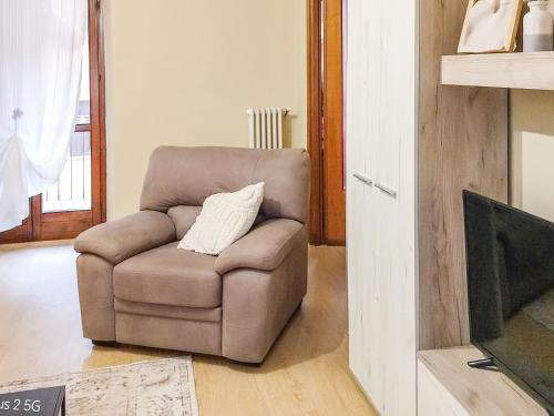 a brown chair with a pillow in a living room at Nel Centro Storico in Luserna San Giovanni