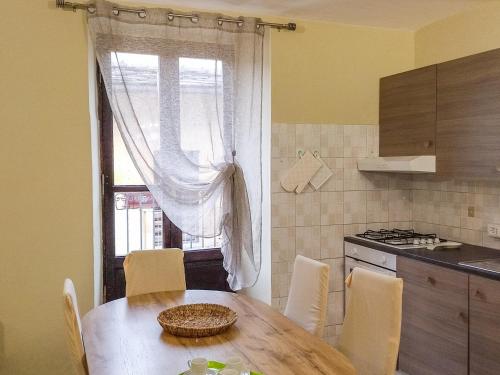 a kitchen with a table with chairs and a window at Nel Centro Storico in Luserna San Giovanni