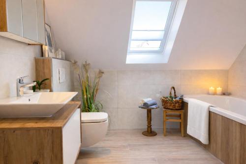 a bathroom with a sink toilet and a skylight at Andi's Auszeit in Dörpen