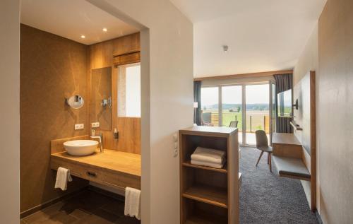 a bathroom with a sink and a counter with a window at Das Weitblick Allgäu in Marktoberdorf