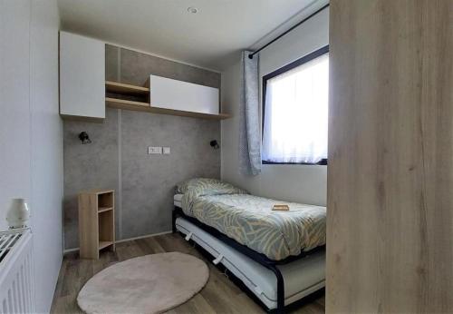 a small bedroom with a bed and a window at Ferienhaus im Naturschutzgebiet in Holland in Lauwersoog