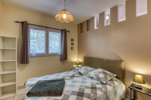 a bedroom with a bed with a checkered blanket at La Colline des Pins in Aniane