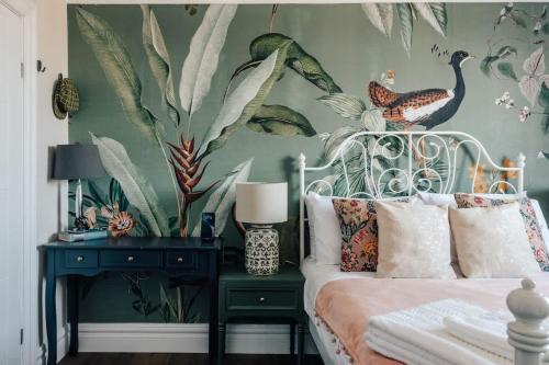 a bedroom with a bed with a tropical wallpaper at Family apartment with balcony 2 min walk to Hyde Park in London
