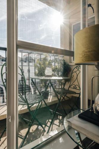 a balcony with a table and a window with a table at Family apartment with balcony 2 min walk to Hyde Park in London