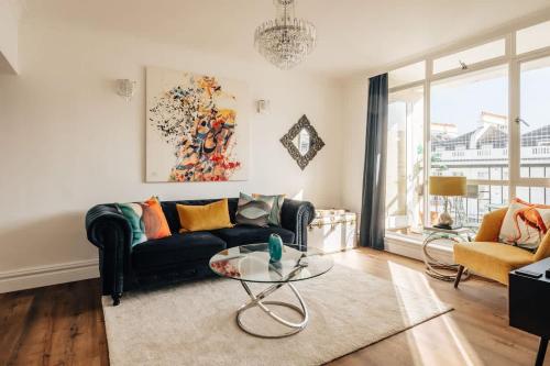 a living room with a couch and a glass table at Family apartment with balcony 2 min walk to Hyde Park in London