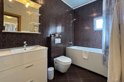 a bathroom with a toilet and a tub and a sink at Ferienwohnung Penthouse Sunce in Bar