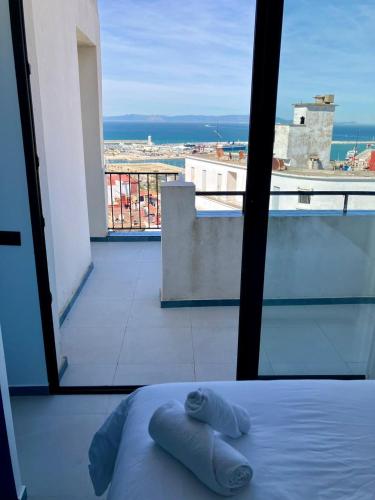 a bed in a room with a view of a balcony at YaYaCaSa in Tangier