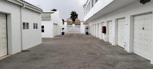 a hallway of white buildings with a person standing on a ladder at On the Beach 20 in Swakopmund