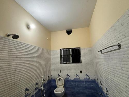 a bathroom with a toilet and a bath tub at Mon Aashray Stay in Guwahati