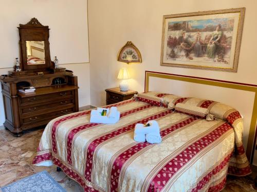 a bedroom with a bed with two towels on it at Suite Apartment Mandorlo in Volterra