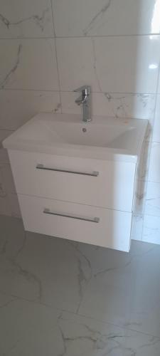 a white sink with a faucet in a bathroom at ELA Apartmani i sobe in Neum