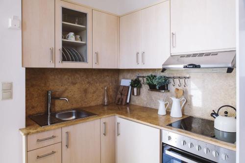 a kitchen with white cabinets and a sink at Studio Apartment By Travel Lets Holiday Homes Lagada With Pool in Makry Gialos