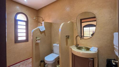 a bathroom with a sink and a toilet and a mirror at Bihi Lodge in Tahannout