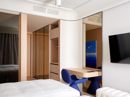 a bedroom with a bed and a desk and a tv at Boutique Hotel Venturo, a Member of Design Hotels in Split