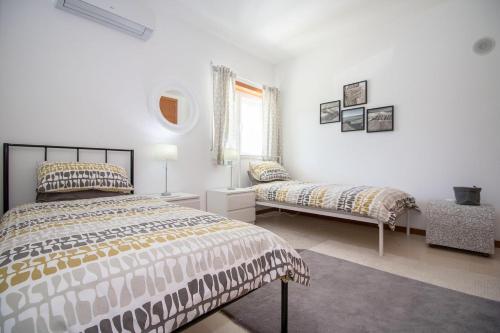 a bedroom with two beds and a window at Villa Granada by Algarve Holidays in Almancil