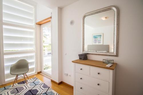 a bedroom with a mirror and a dresser and a chair at Villa Granada by Algarve Holidays in Almancil