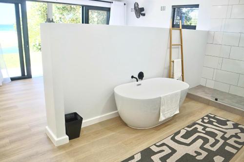 a bathroom with a bath tub and a rug at Chintsa Oceanfront in Chintsa