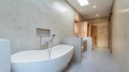 a bathroom with a large tub in a room at Diva Villa Sanggingan Ubud in Ubud