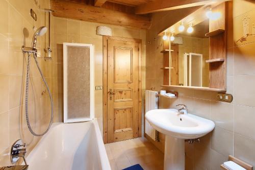 a bathroom with a sink and a tub and a toilet at Baita Del Canton in Valdidentro