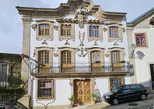 a building with a car parked in front of it at Casa Matriz Séc XVI in Penafiel