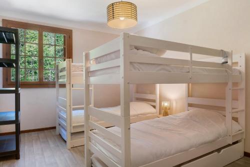 a bedroom with two bunk beds and a window at Maison L'arrieulat in Argelès-Gazost