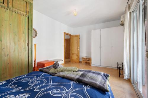 a bedroom with a bed with a blue blanket on it at Casacuéntame in Granada