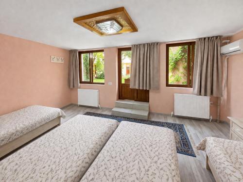 a bedroom with two beds and two windows at Hotel & Hostel Siyob Samarkand in Samarkand
