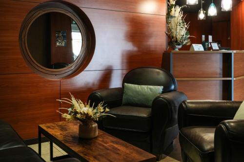 a waiting room with a chair and a mirror at Logis Hôtel Le Relais in Biscarrosse