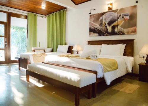 a bedroom with two beds and aulture painting on the wall at vainika wild sigiriya in Sigiriya