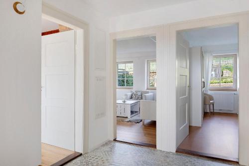 a hallway with white doors and a living room at Feierabend am Kaiserstuhl in Bötzingen