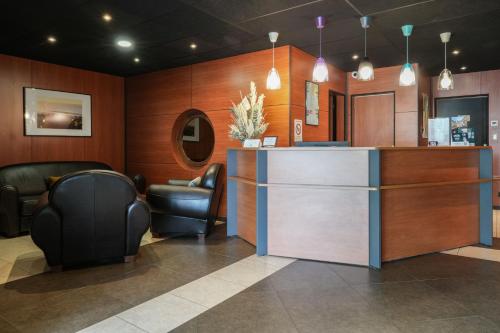 a waiting room with two chairs and a counter at Logis Hôtel Le Relais in Biscarrosse