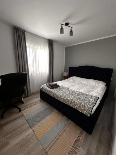 a bedroom with a bed and a chair and a window at Cabanuta in Brașov in Braşov