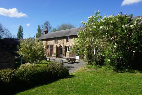 a stone house with a picnic table in front of it at Le Petit Lustucru in Saint-Martin-des-Champs