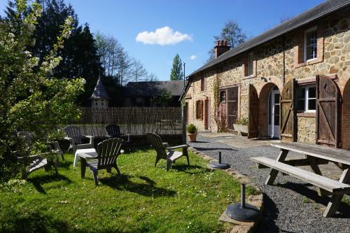 a picnic table and chairs in the grass next to a building at Le Petit Lustucru in Saint-Martin-des-Champs