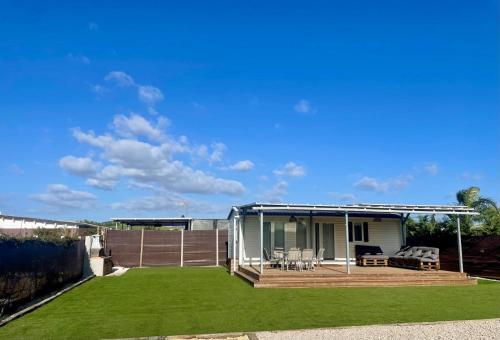 a small house with a patio and grass at El Palmar Paradise in El Palmar