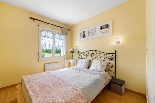 a bedroom with a bed and a window at Chambre d'hôtes Les Loges in Luçon