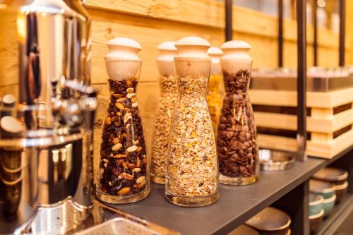 a row of glass vases filled with nuts and seeds at AvenidA Panorama Suites in Kaprun