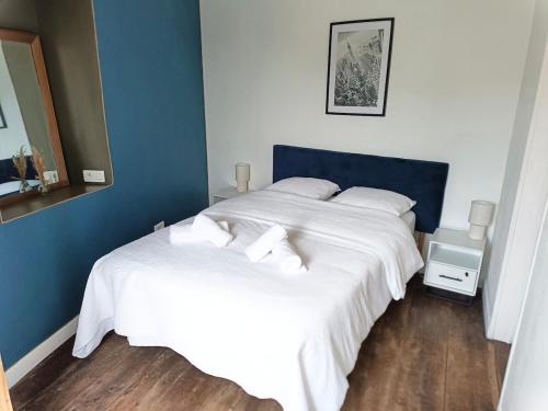 a bedroom with two beds with white sheets and blue walls at Maison les Alouettes in Nevers