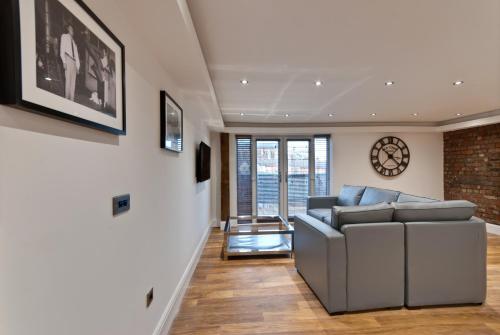 a living room with a couch and a brick wall at The Picture House Apartments in Liverpool
