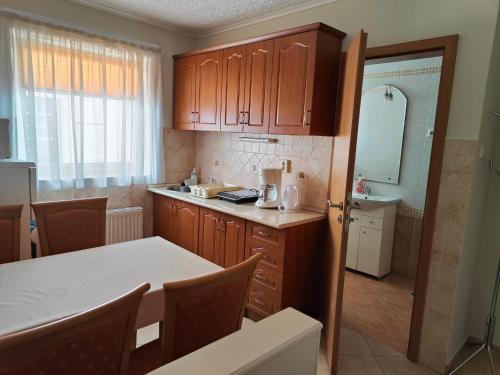 a kitchen with wooden cabinets and a white counter top at Sárga Apartman Ház in Balatonfüred