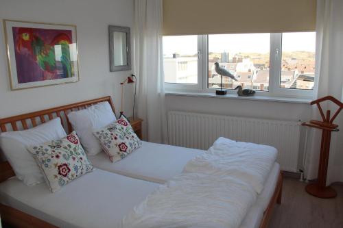 a bedroom with two beds and a window at Apartments with unique sea view in Egmond aan Zee