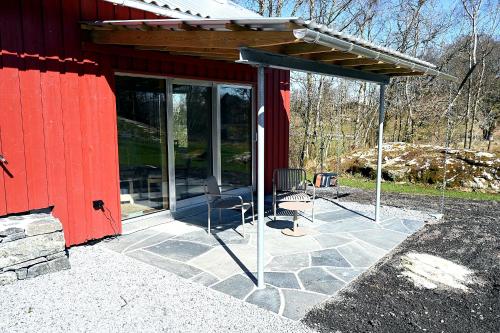 a screened in porch of a red building with a chair at Østhusvik Cabin in Stavanger