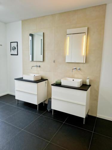 a bathroom with two sinks and two mirrors at Villa in Meisenheim