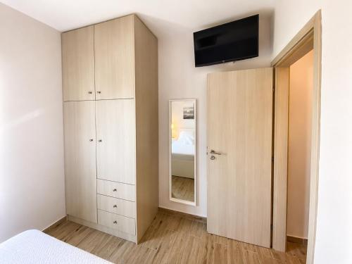 a bedroom with a cabinet and a mirror at Elli's House - Apartment in Lixouri